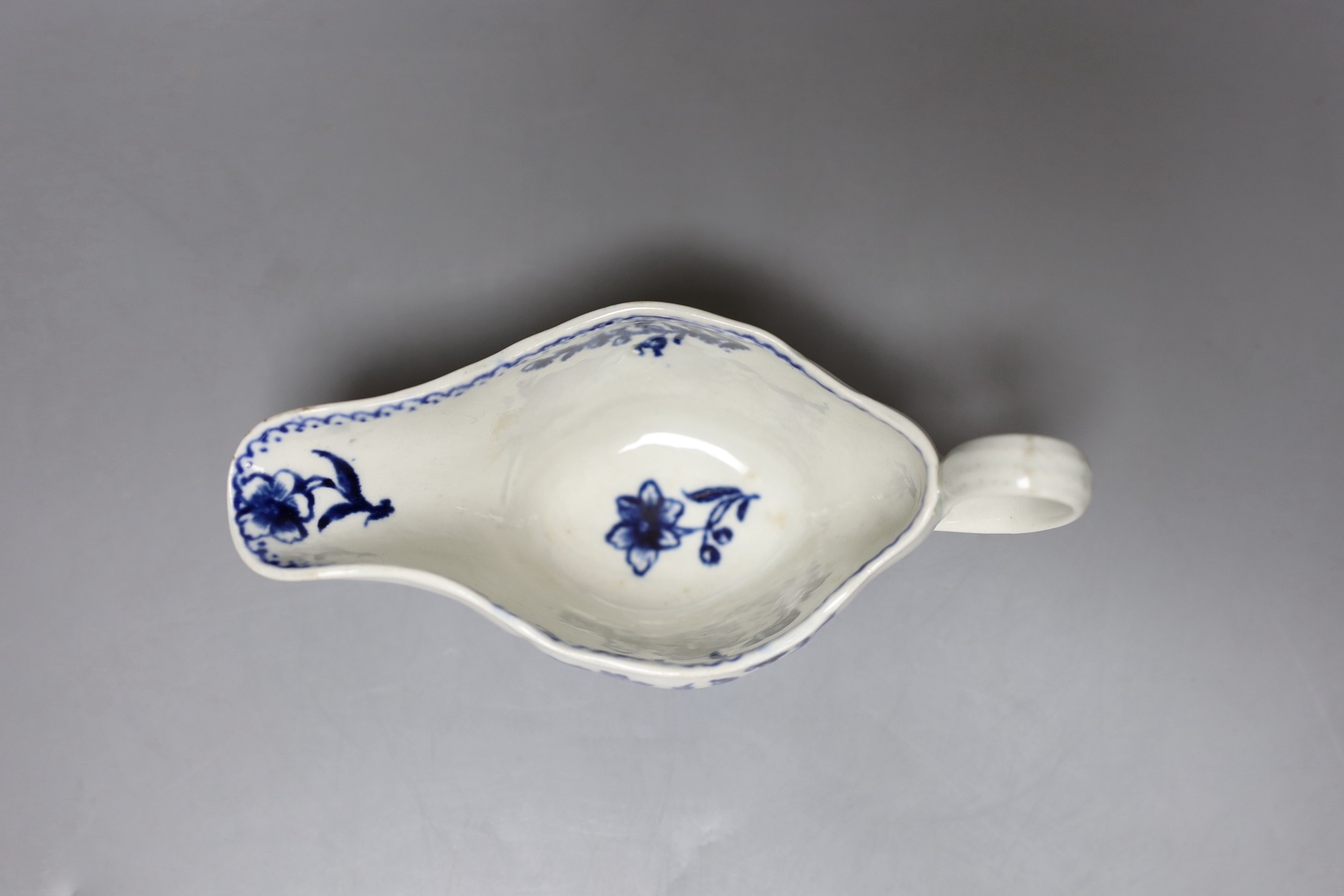 A Liverpool sauceboat decorated in blue underglaze flowers, the interior with further flowers and a dot and loop border, 16cm long